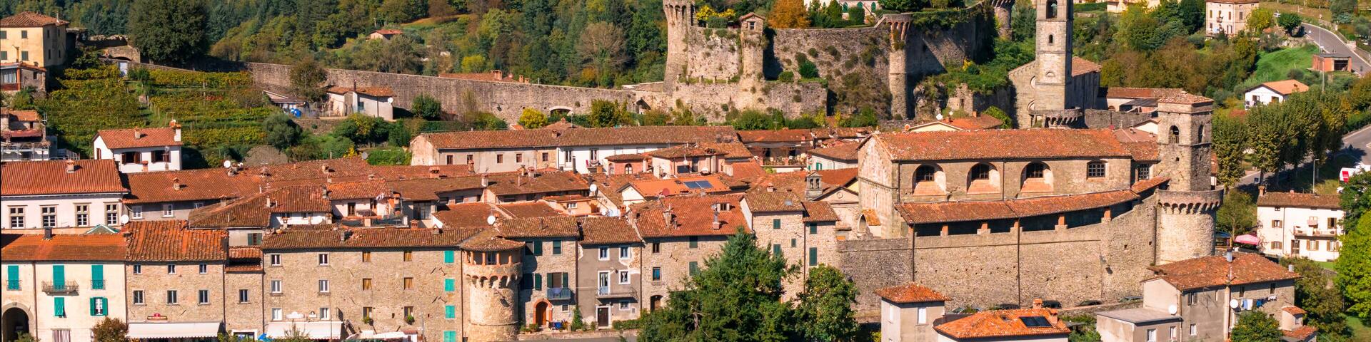 A historic town with medieval architecture, including a prominent tower and fortified walls.