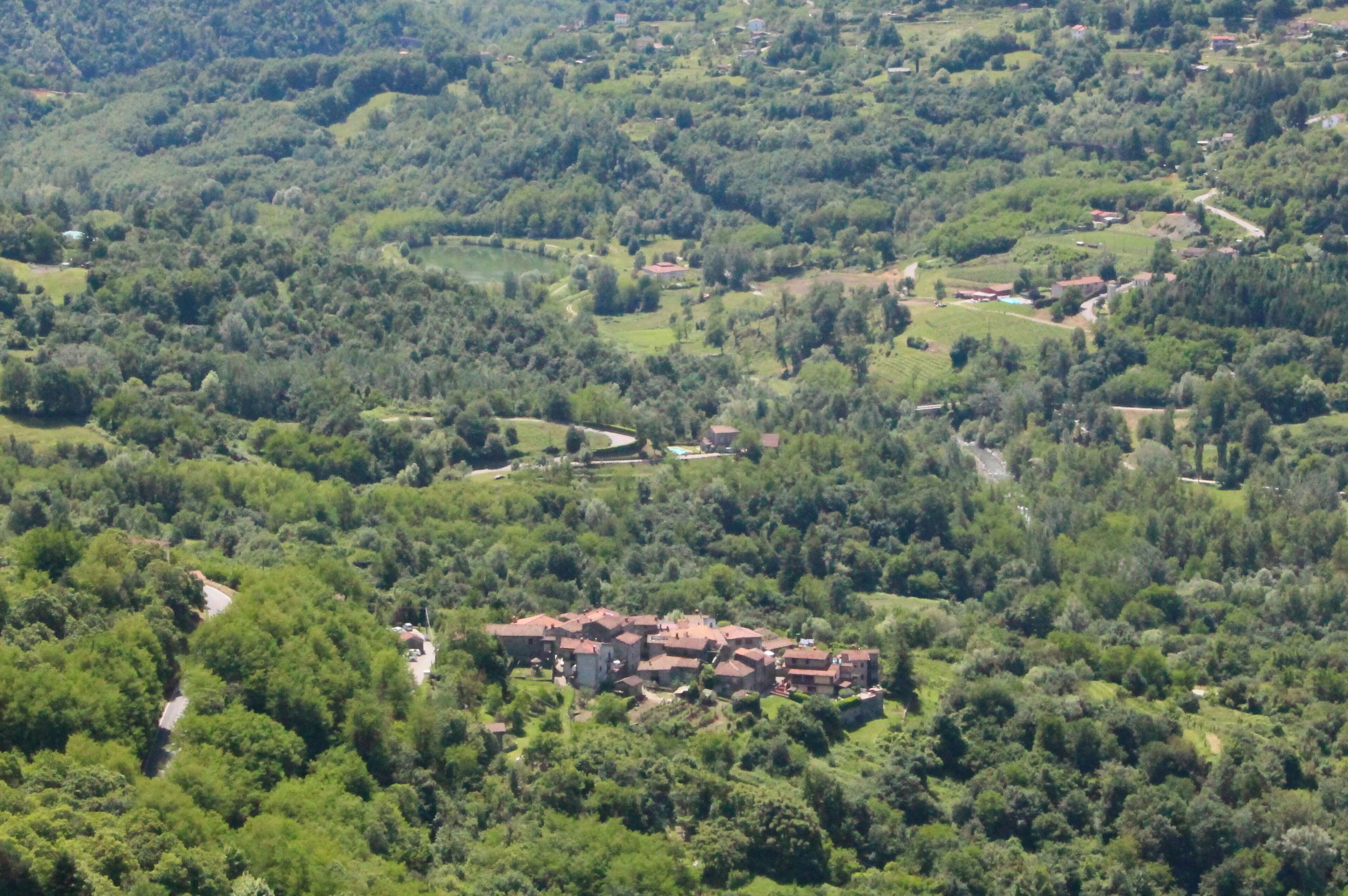 A lush green valley with scattered houses and a winding road.