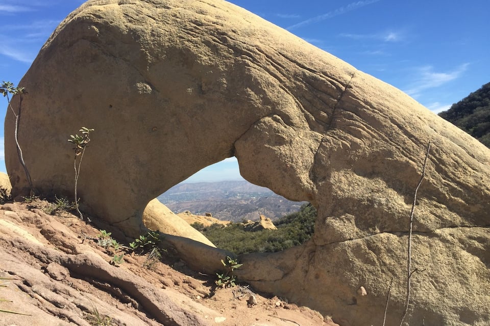 Uma grande formação rochosa com um arco natural.