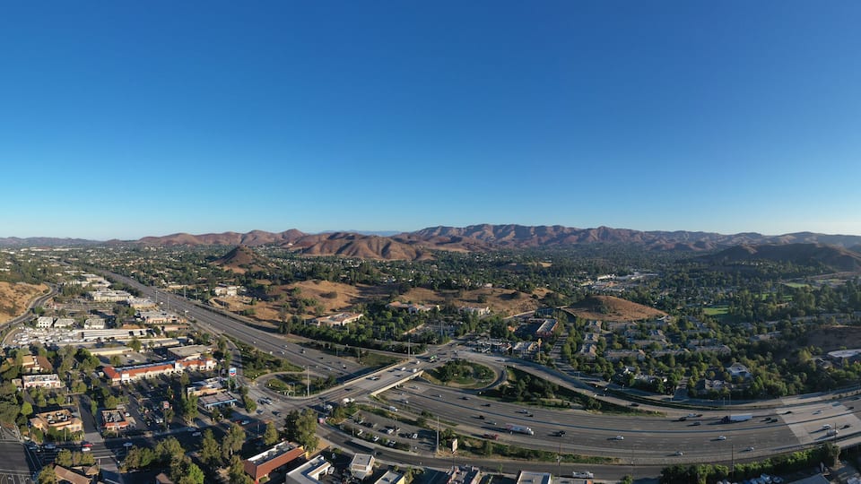 A city with a highway and surrounding mountains.