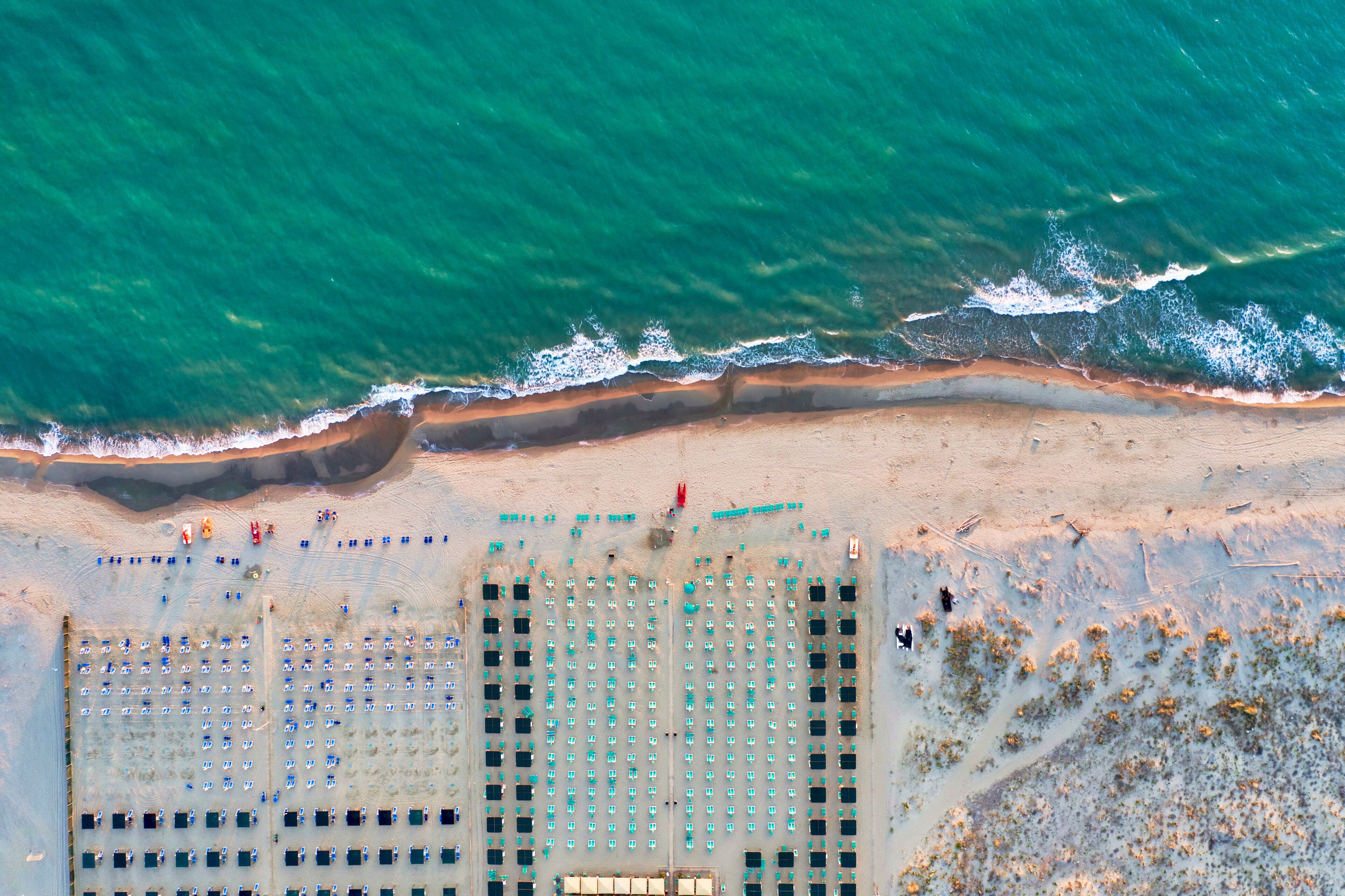 Italy, Tuscany, Torre del Lago Puccini, boathouse and neatly ordered beach chairs and umbrellas