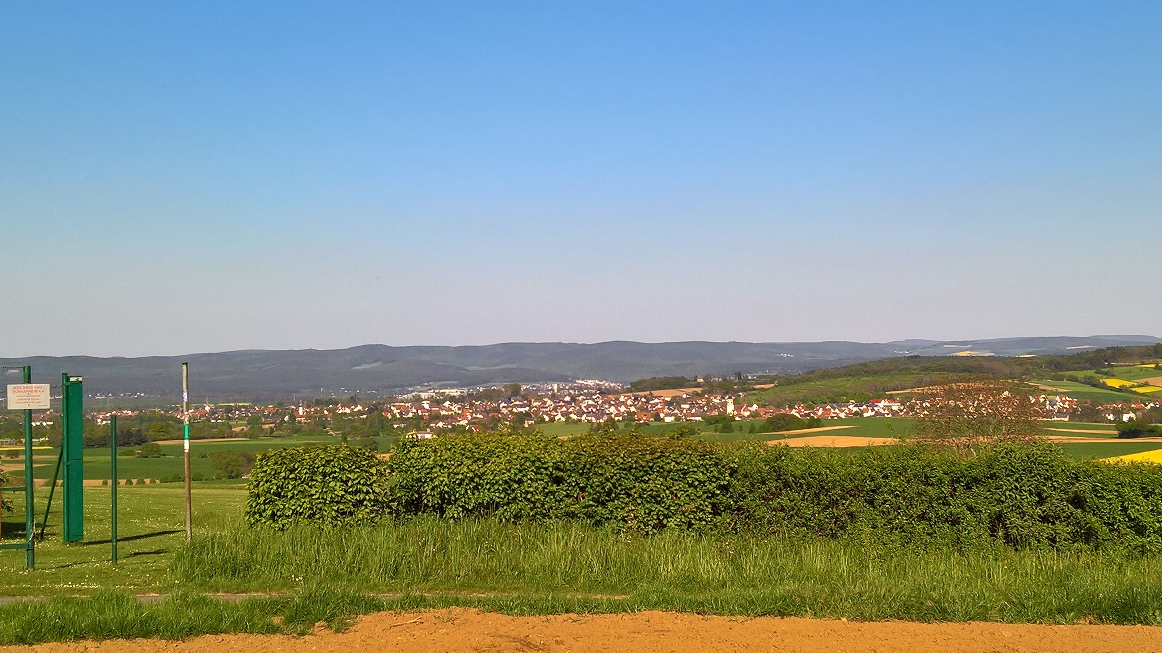 Ansicht von der Schaafheimer Warte ins Pflaumbachtal nach Pflaumheim mit den Odenwaldausläufern; dahinter nicht sichtbar das Maintal, am Horizont die Spessarthöhen