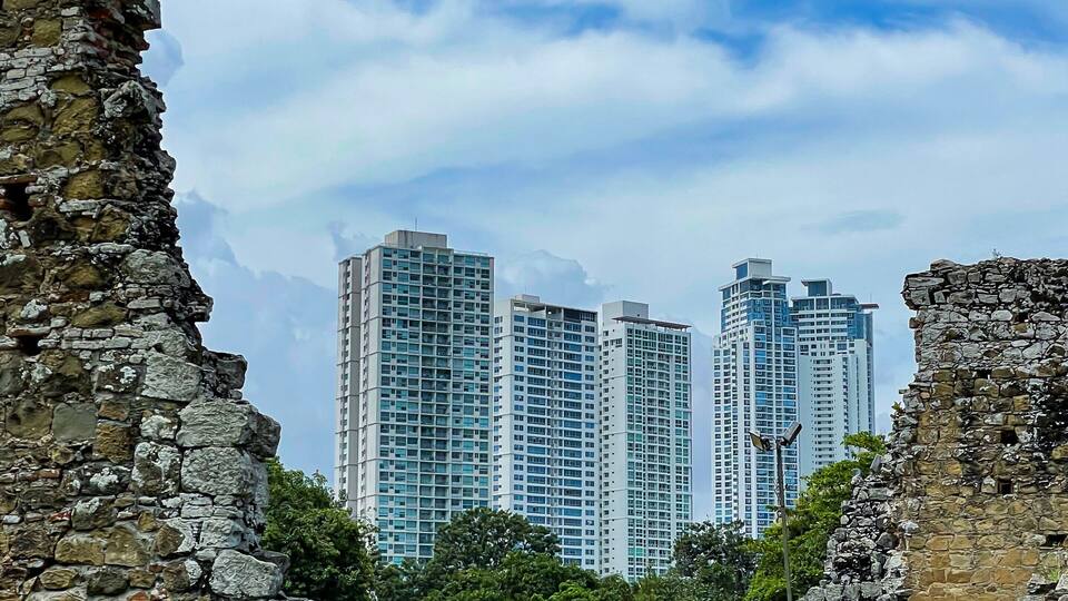 Old ruins of historic city of Panama Viejo, framing modern multi-story buildings