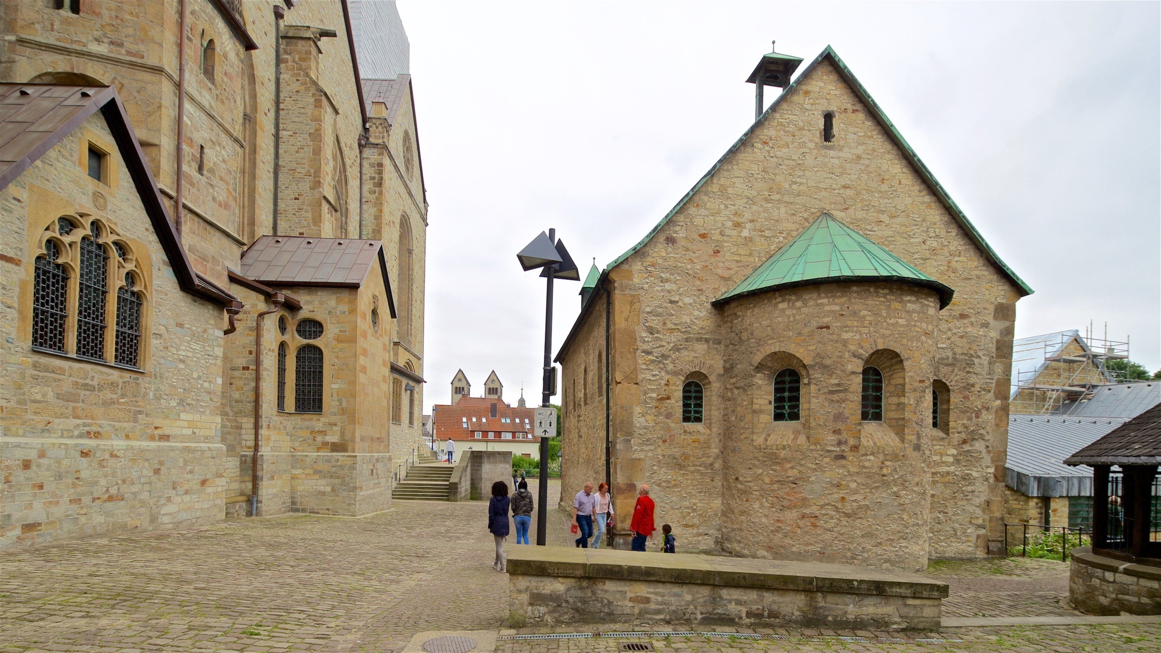 Paderborner Dom das einen Geschichtliches und Straßenszenen sowie kleine Menschengruppe