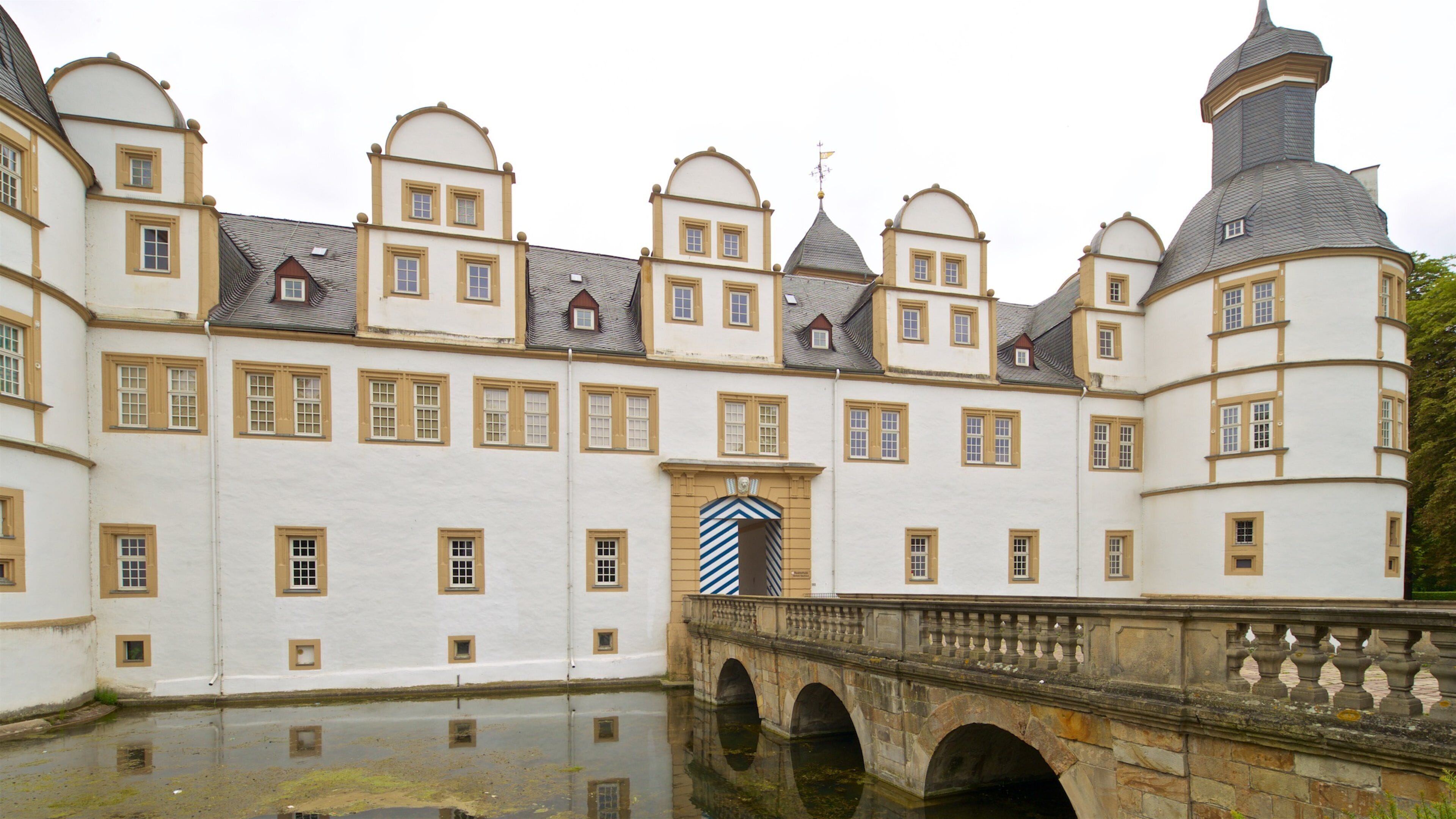 A historic building with multiple arched windows and a central entrance with a striped archway.
