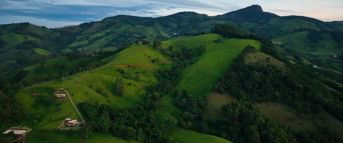 Rolling green hills, a winding road, and a prominent hilltop structure.