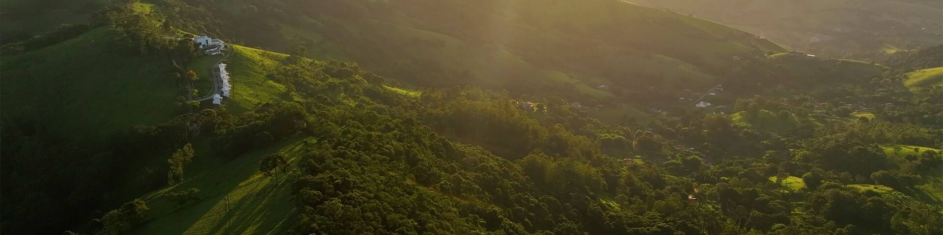 Aerial view of breathtaking mountains and lush green valley at sunset, Monte Verde, Brazil.