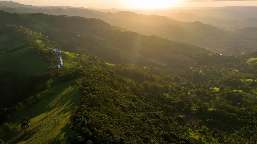 Aerial view of breathtaking mountains and lush green valley at sunset, Monte Verde, Brazil.