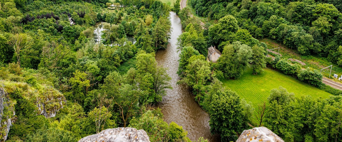 A river winding through a lush valley with dense forests on either side.