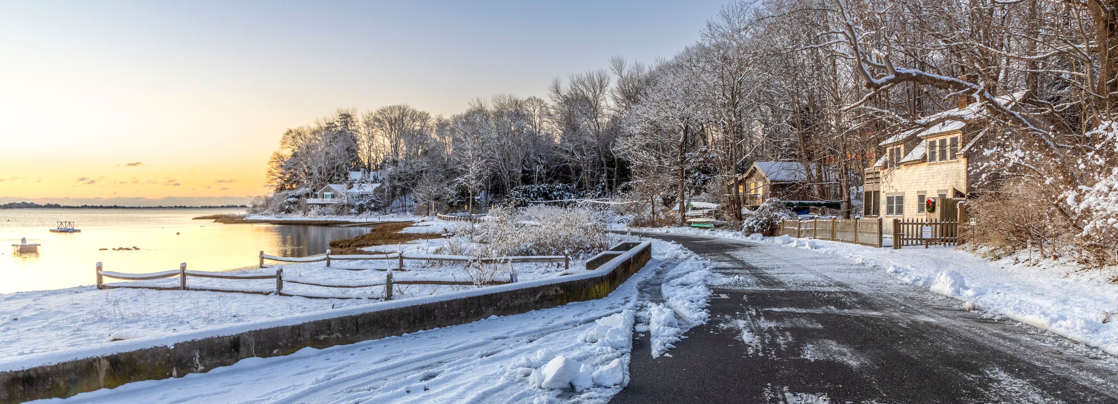 Panoramic shot of houses surrounded by snowy trees near the lake in Cotuit, Massachusetts