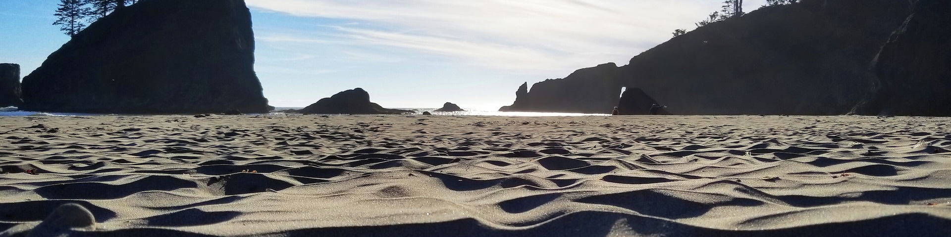 Hiking around the Pacific Northwest. Stopped to take an break at dusk to enjoy the sunset along the coast of the Pacific ocean. Silhouettes of rocks stretching from the waters and toward the sky. #adventure #ocean #pacificocean #hiking #travel #coastline #shores #sunset #rocks #trees #sand #dream #breathe