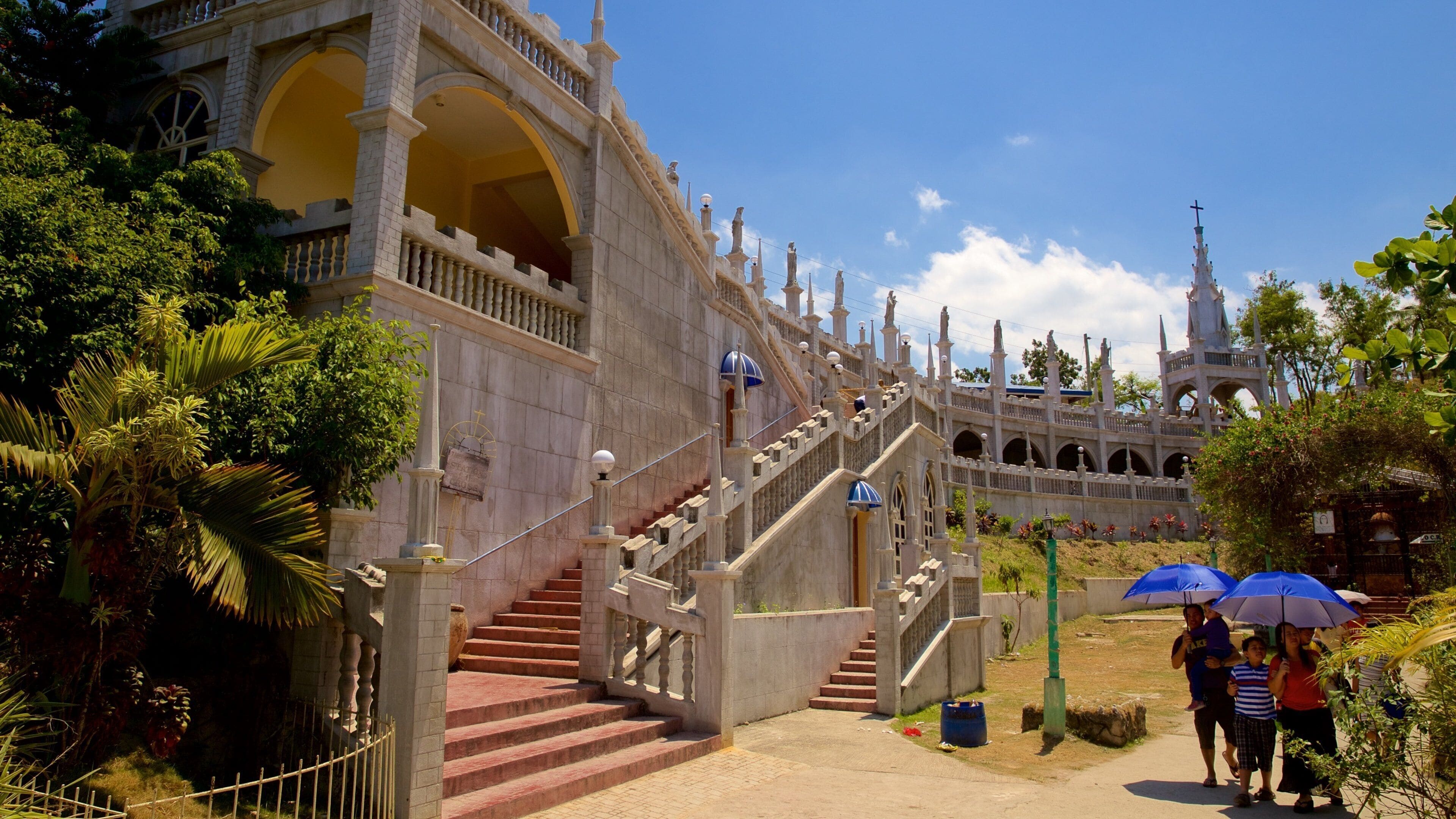 A grand, ornate building with a large staircase leading to a balcony.