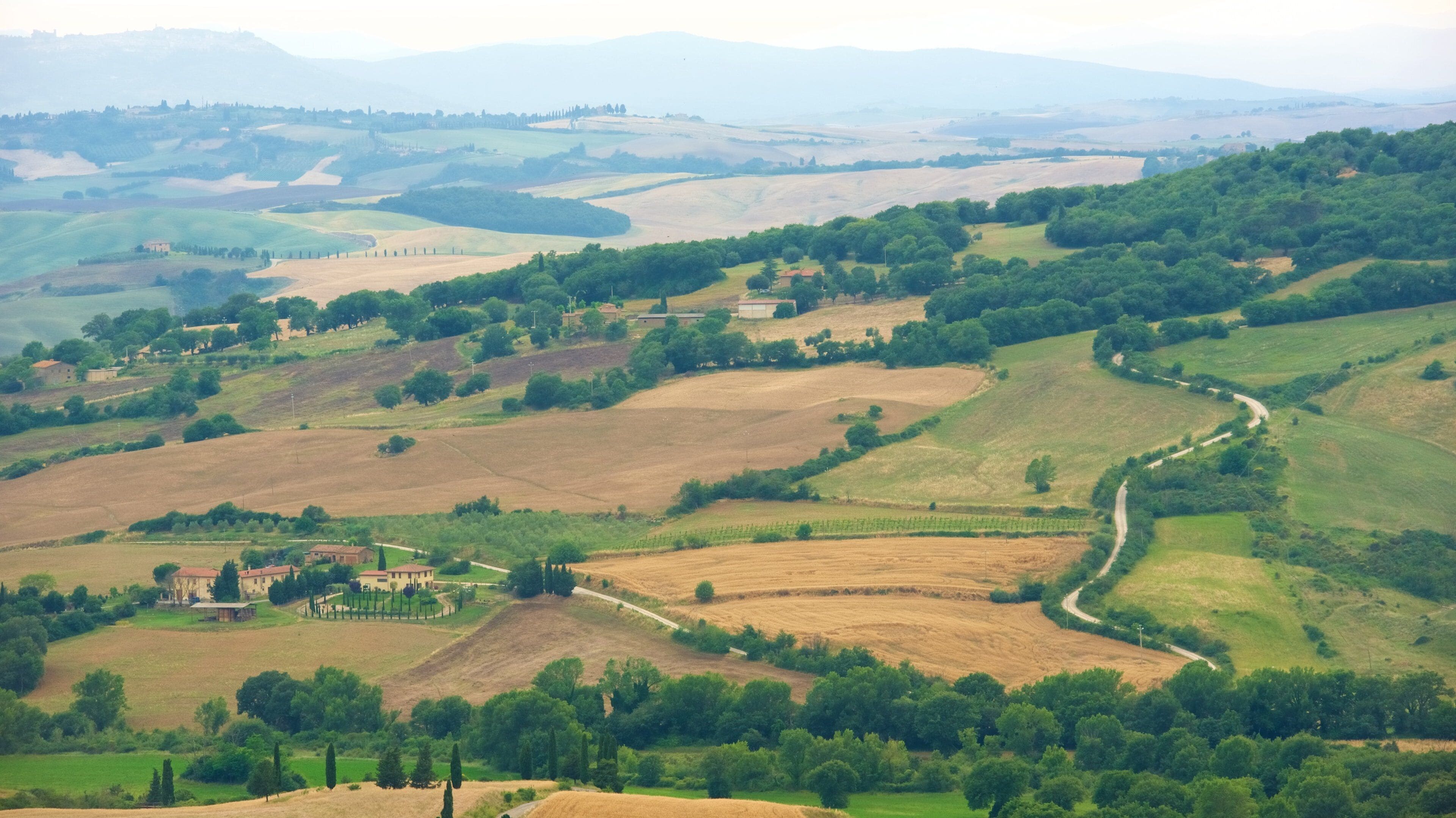 Rolling hills, vineyards, and scattered buildings in a rural landscape.
