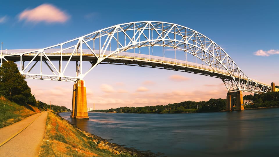 A large steel bridge spanning a river with a clear sky.