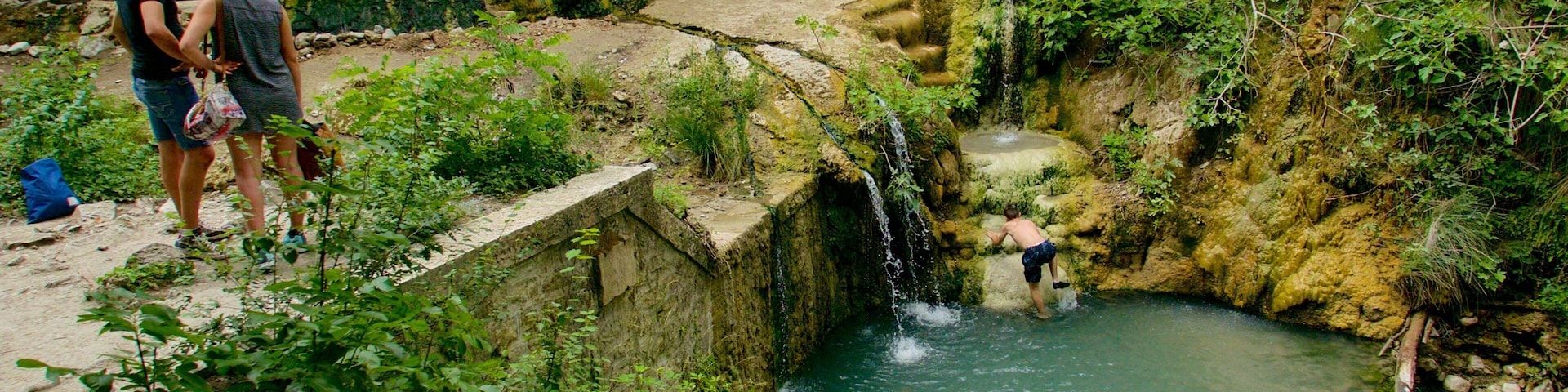 Bagni San Filippo which includes a lake or waterhole and swimming as well as a small group of people