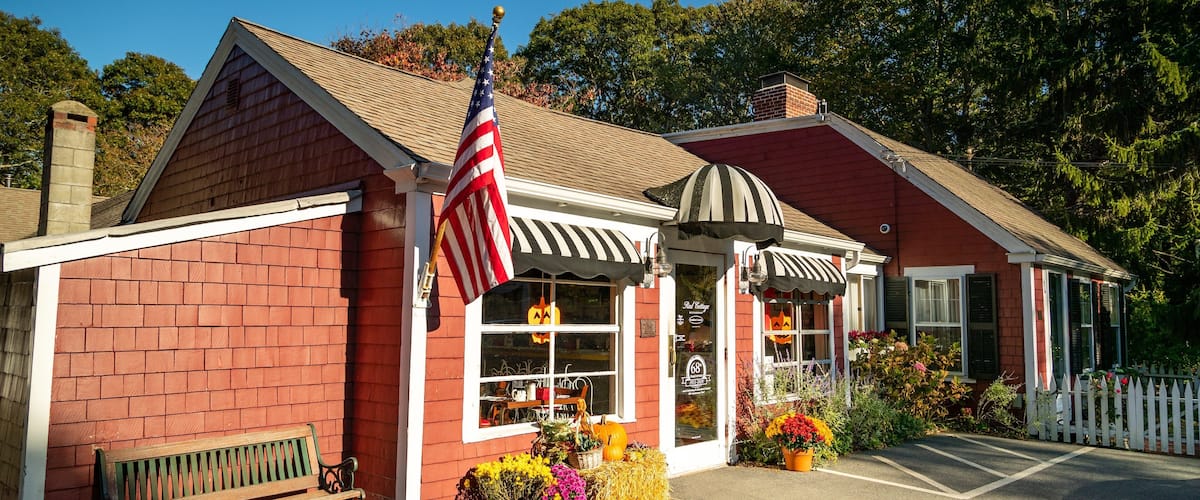 A red brick building with a white awning and an American flag.