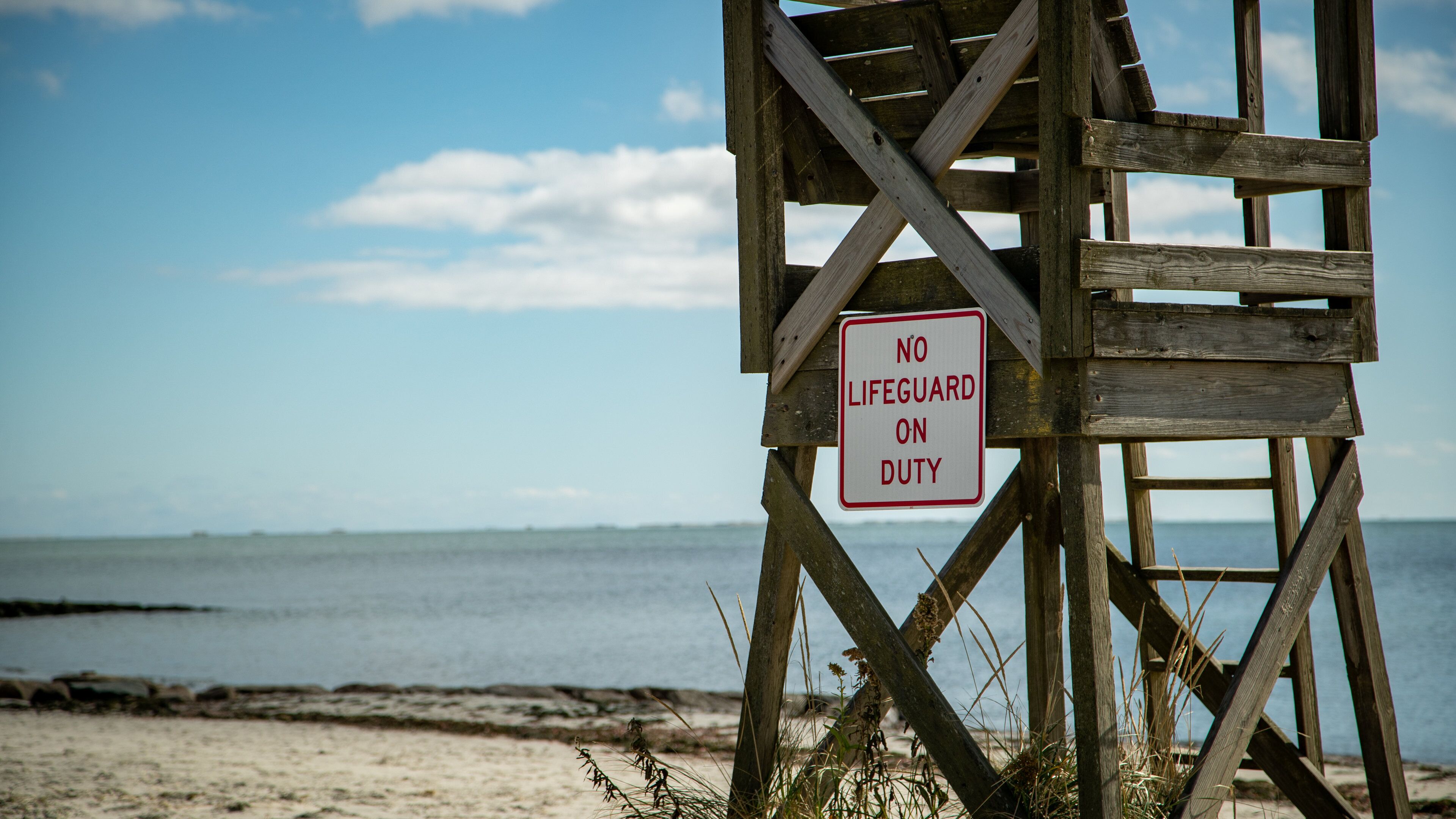 South Harwich showing a sandy beach, signage and general coastal views