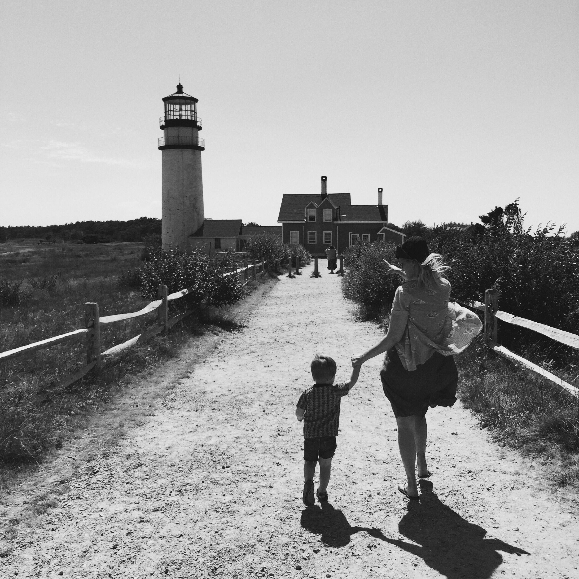 A dirt path leading to a lighthouse and a house.