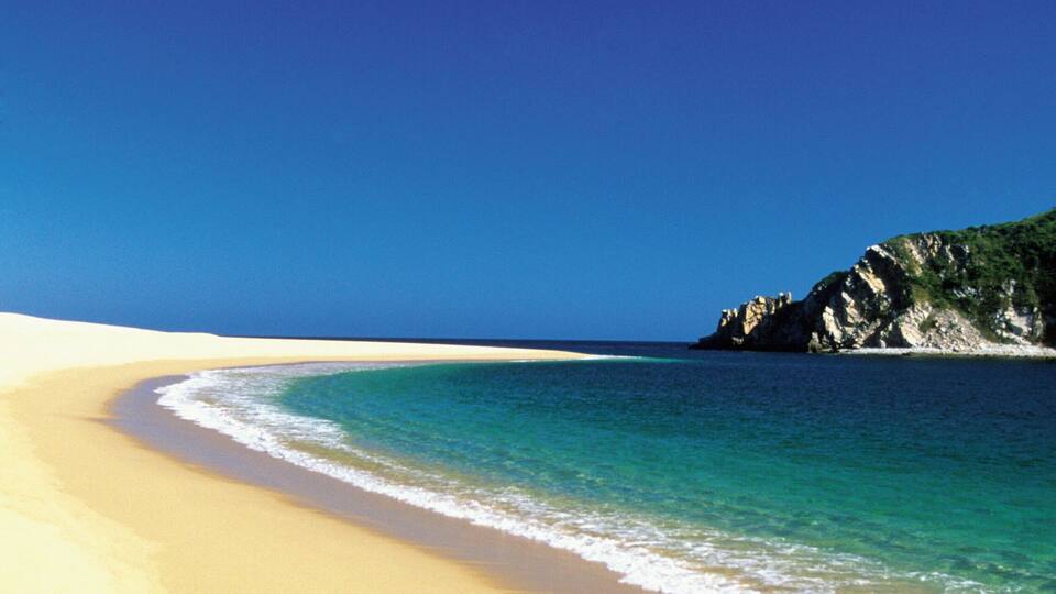 Footprints in the sand on Cacaluta Bay beach in Huatulco, Mexico