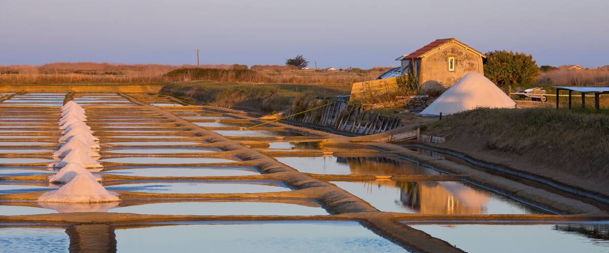 A salt flat with a salt dome and a small building.