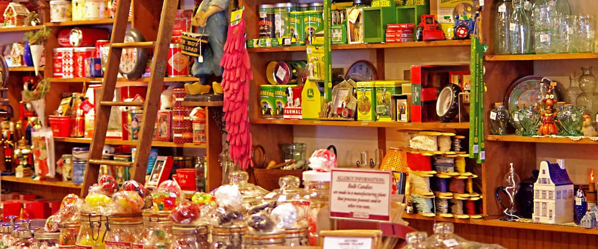 A cluttered shop with shelves full of jars, tins, and glass bottles.