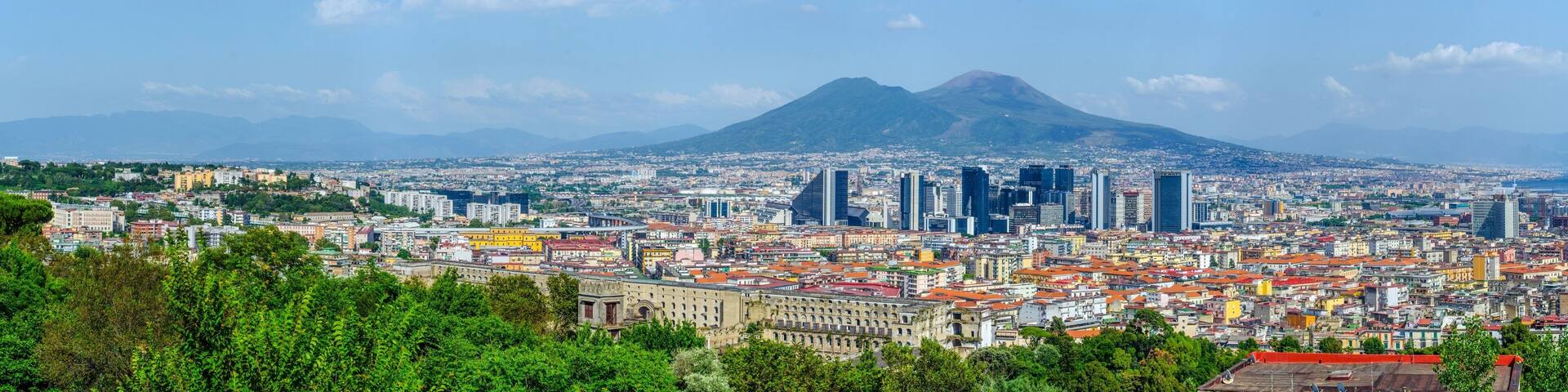 aerial view of centro direzionale business district in naples with mount vesuvius behind.