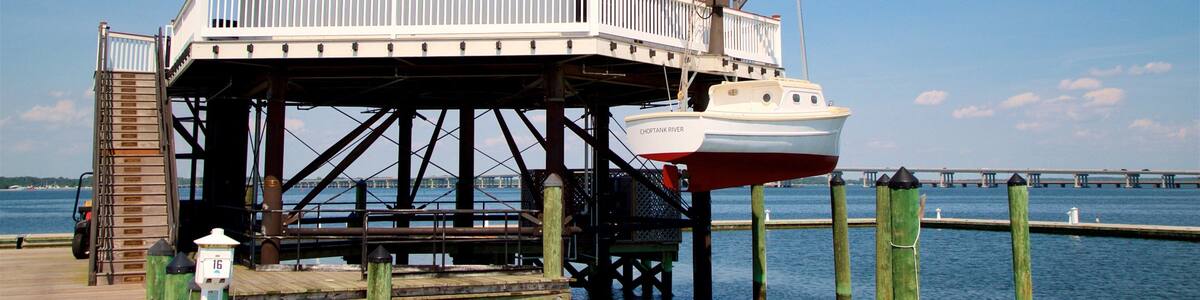 A lighthouse on a pier with a boat docked below.