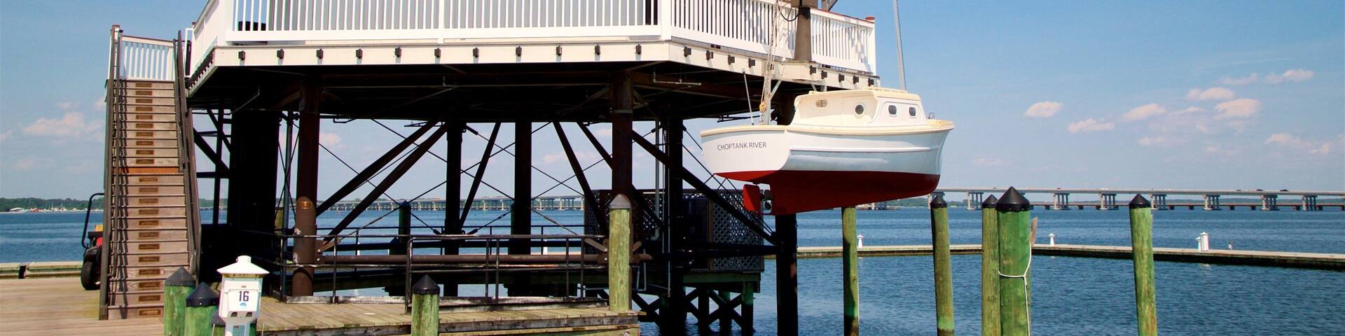 A lighthouse on a pier with a boat docked below.