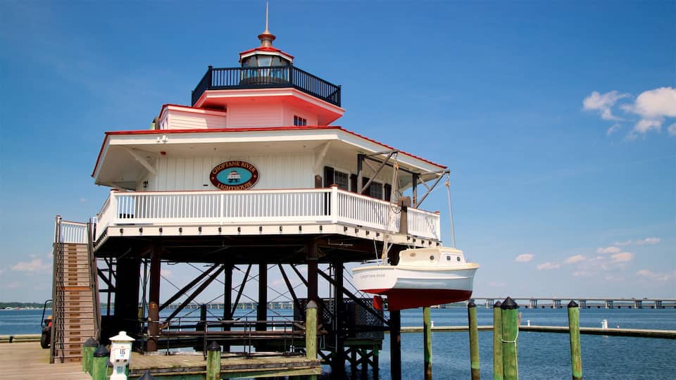 A lighthouse on a pier with a boat docked below.