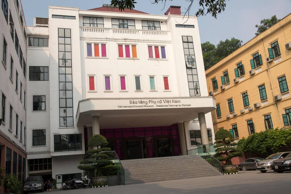Un edificio moderno con contraventanas de colores, una escalera que lleva a la entrada y un cartel que dice "Bảo tàng Phương Việt Nam".