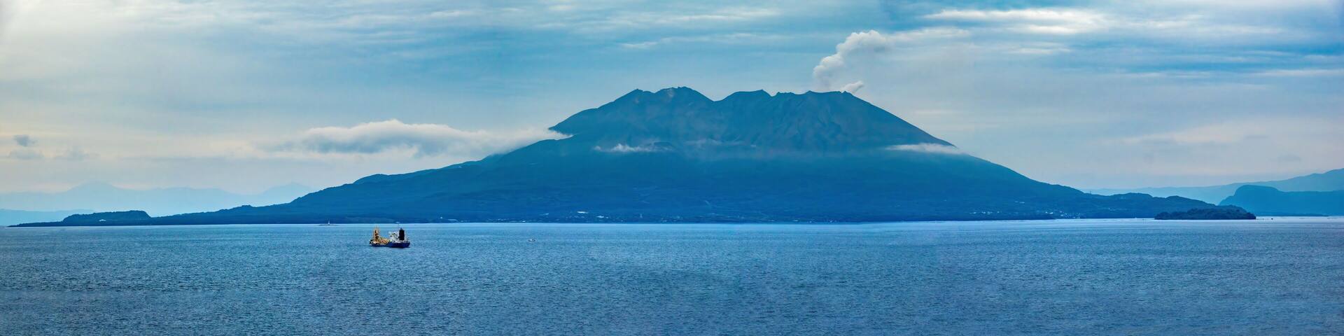 Panoramic view of the Sakurajima volcano in eruption from the shores of the city of Kagoshima, Kyushu, Japan