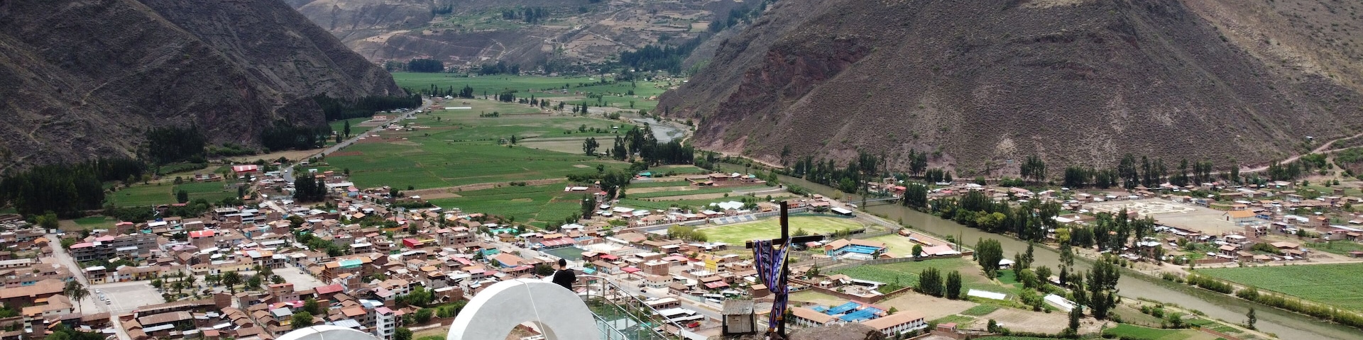 A mountainous landscape with a valley, a river, and a town with colorful buildings.