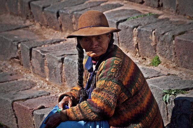While transitting on the Inka Express bus from Cusco to Puna we had a stopover in Andahuaylillas.  Pretty small town, with the highlight being a small church (San Pedro de Andahuaylillas) that's a few hundred years old.

I'm generally not too enamored with old churches so opted to go people watching instead.  This lady was sitting on the steps of the church.
