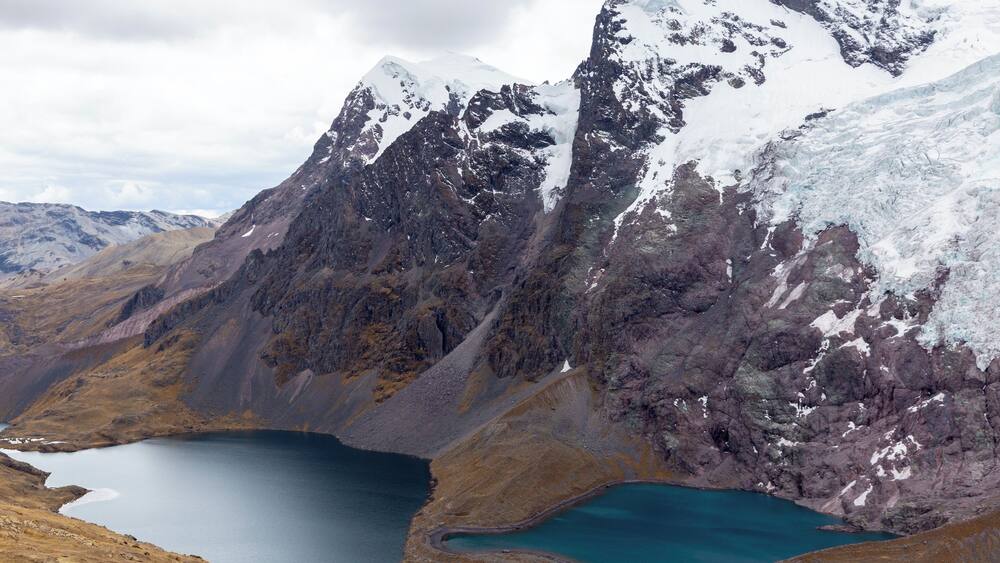 A rugged mountain landscape with a turquoise lake nestled in a valley.