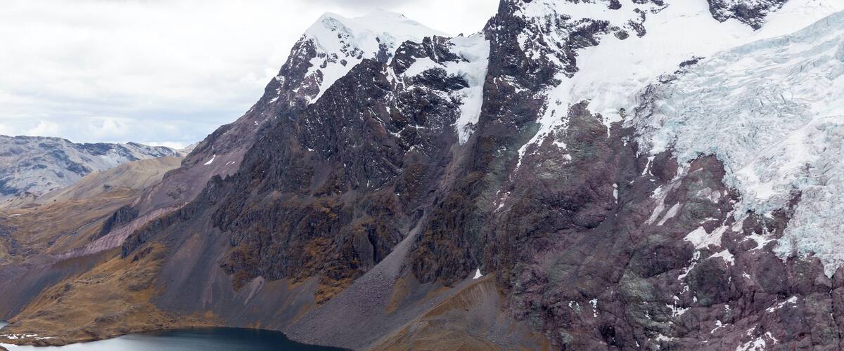 A rugged mountain landscape with a turquoise lake nestled in a valley.