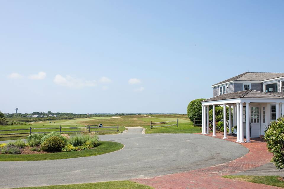 A golf course with a clubhouse and a clear sky.