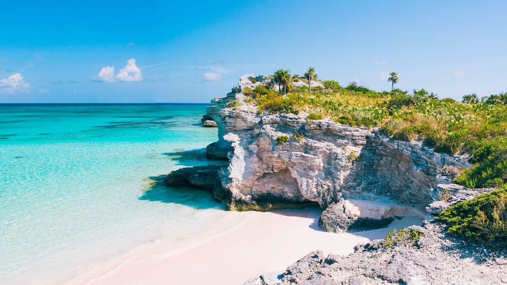 Turquoise blue waters, dramatic limestone cliffs, and powder soft white sand beach at Lighthouse Point on the island of Eleuthera, The Bahamas