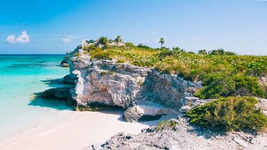Turquoise blue waters, dramatic limestone cliffs, and powder soft white sand beach at Lighthouse Point on the island of Eleuthera, The Bahamas