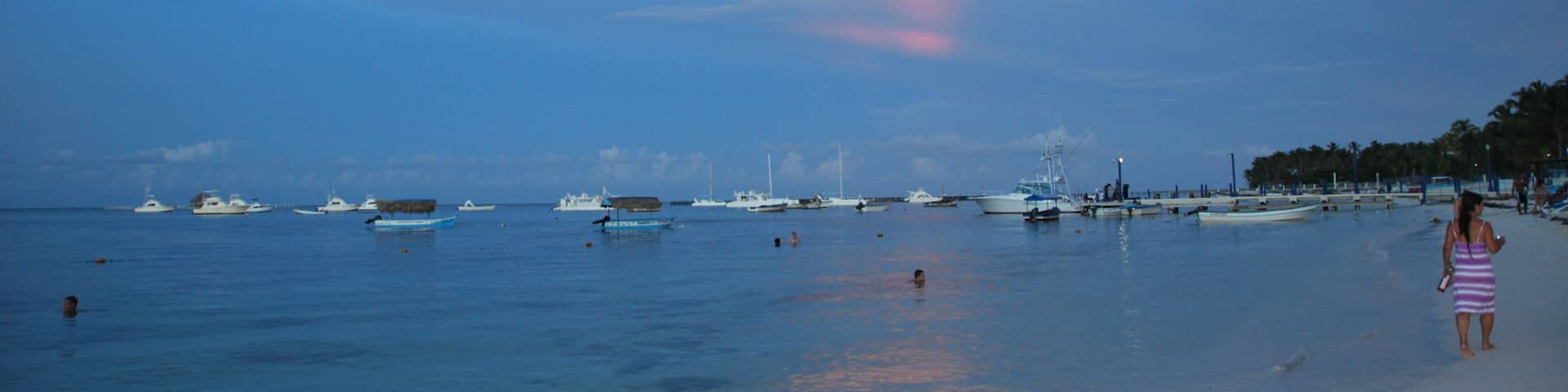 Pleasure and fishing ships are on the raid near the beach at sunset. Punta Cana, Dominican