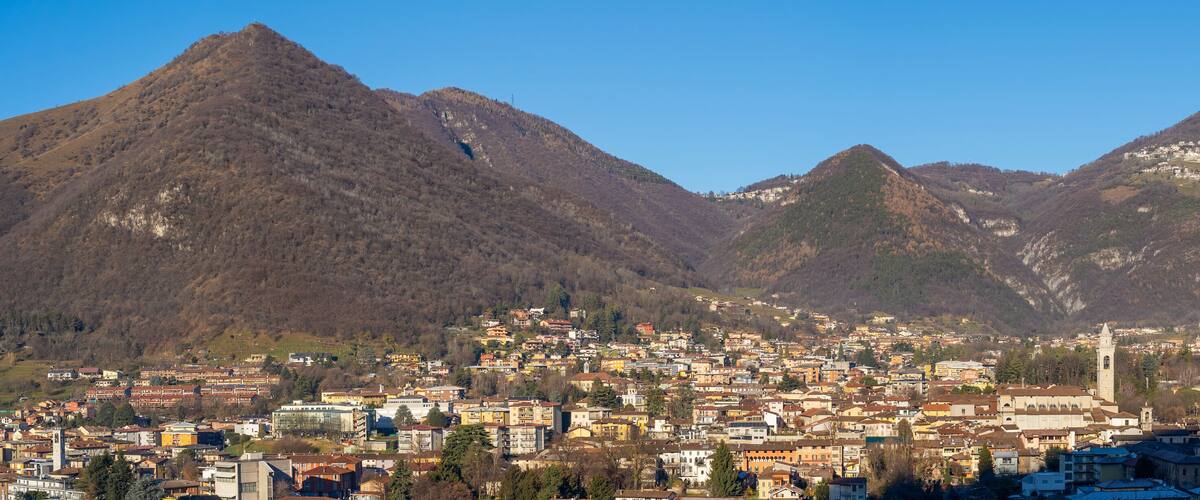A town nestled between mountains with a prominent church tower.