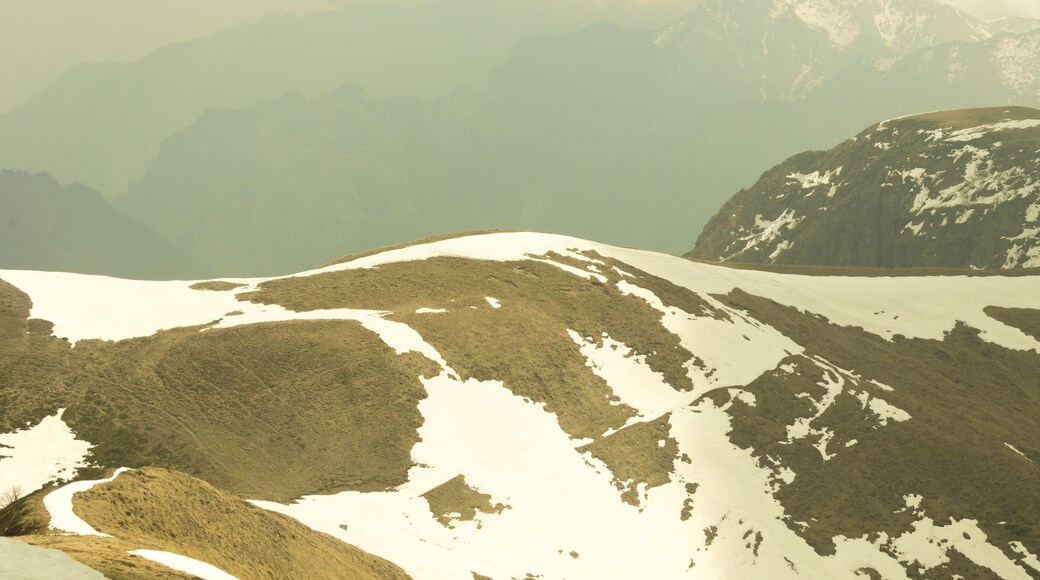 Een bergketen met besneeuwde toppen en een dal.