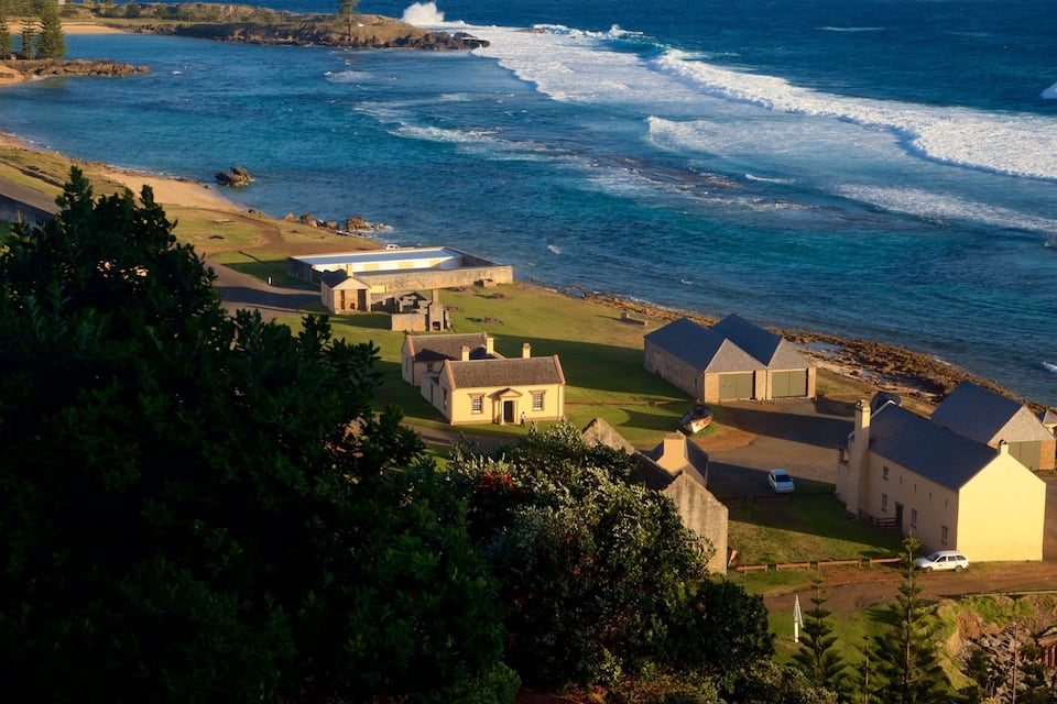 A coastal village with stone buildings and a beach.