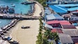 A coastal town with a beach, boats, and buildings.