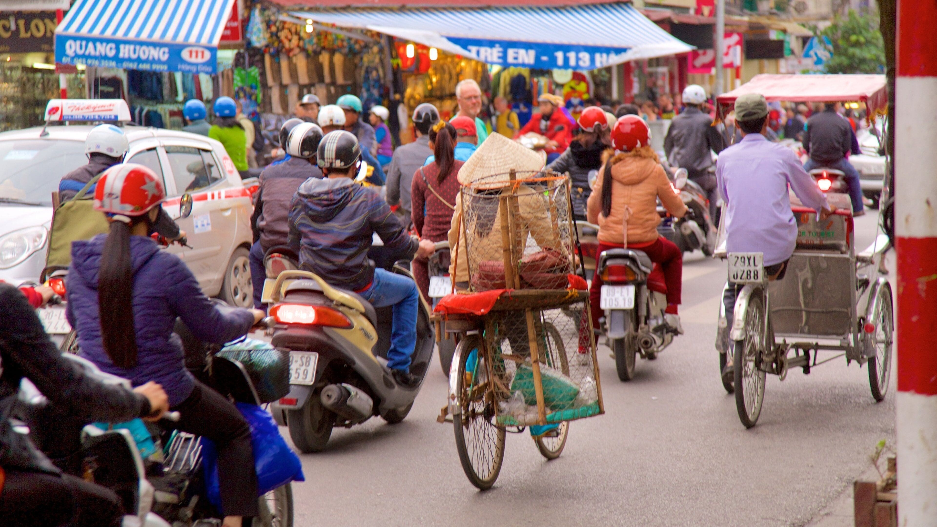 Hang Gai Street featuring cycling and street scenes as well as a large group of people