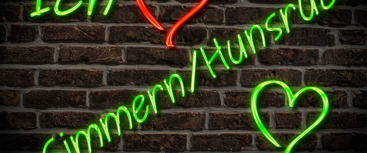 A neon sign on a brick wall with the text "Ich ♥ Simmern/Hunsruck" and a heart symbol.