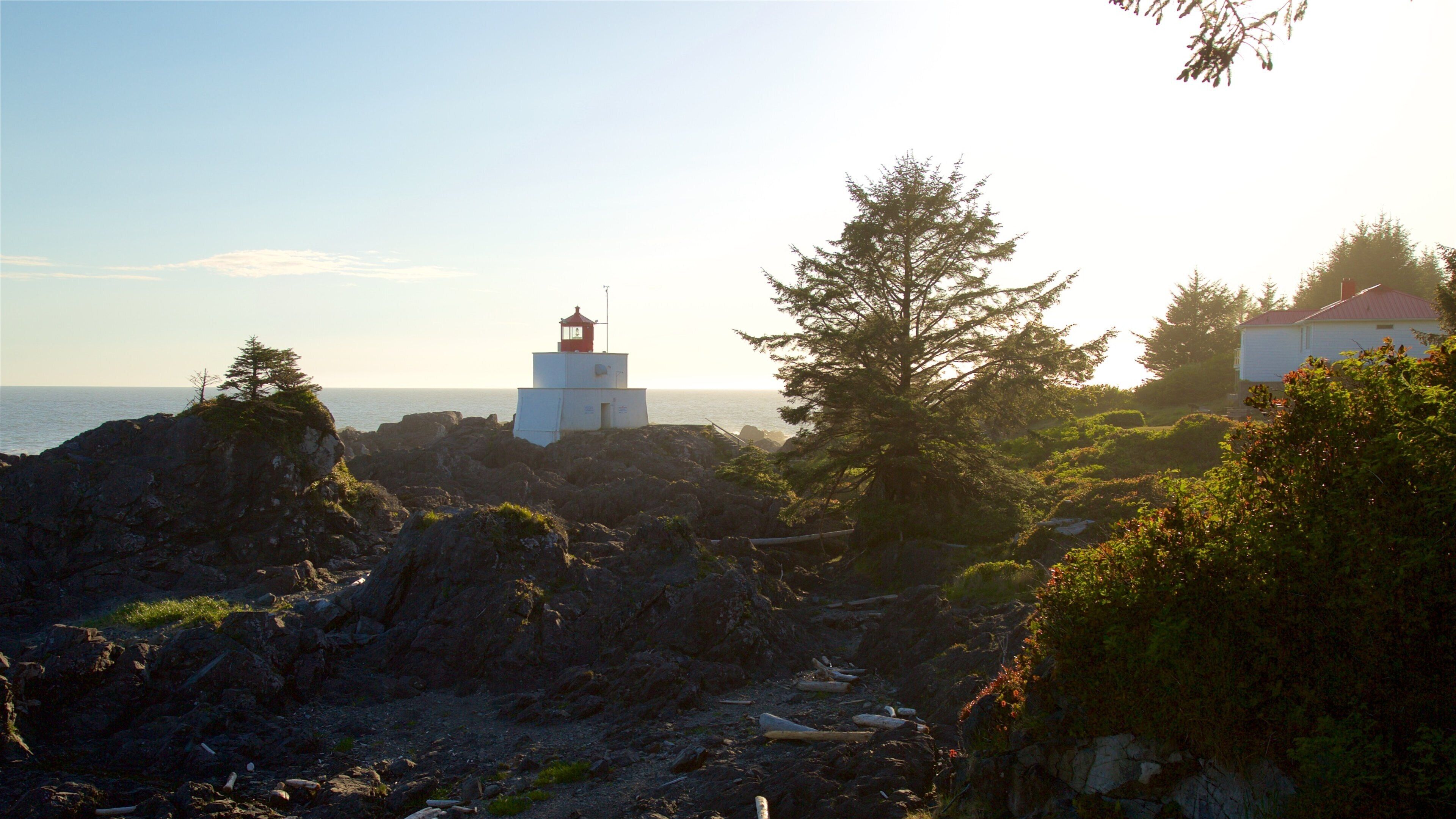 Amphitrite Point Lighthouse featuring a sunset, a lighthouse and rocky coastline