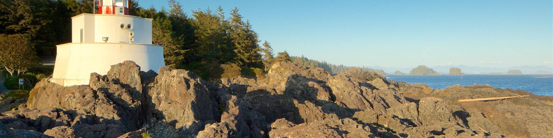 Amphitrite Point Lighthouse featuring a lighthouse, a sunset and rugged coastline