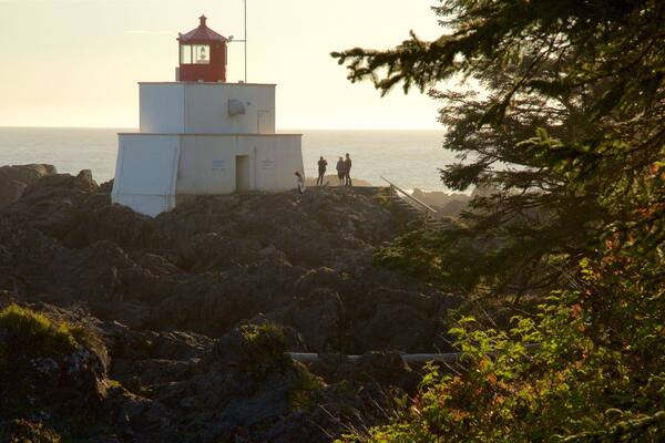 Faro de Amphitrite Point que incluye vistas de una costa, un atardecer y litoral accidentado