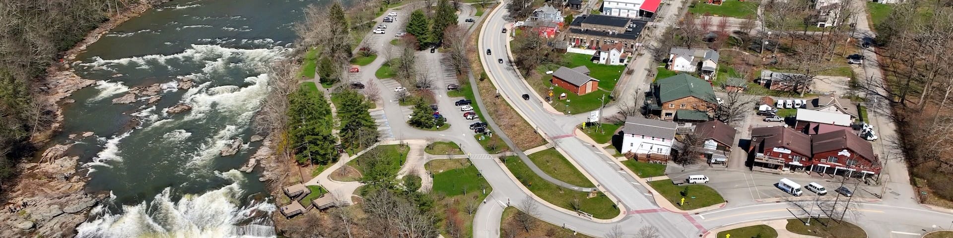 A river with a waterfall, a roundabout, and residential buildings.