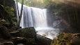 A waterfall surrounded by rocks and trees.